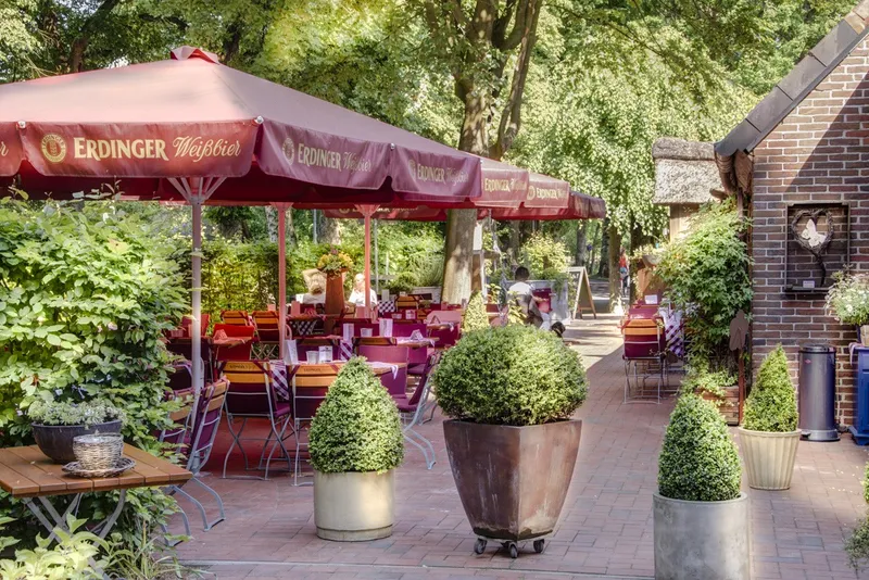 Biergarten mit Sonnenschirmen unter alten Bäumen im Zum Drögen Hasen