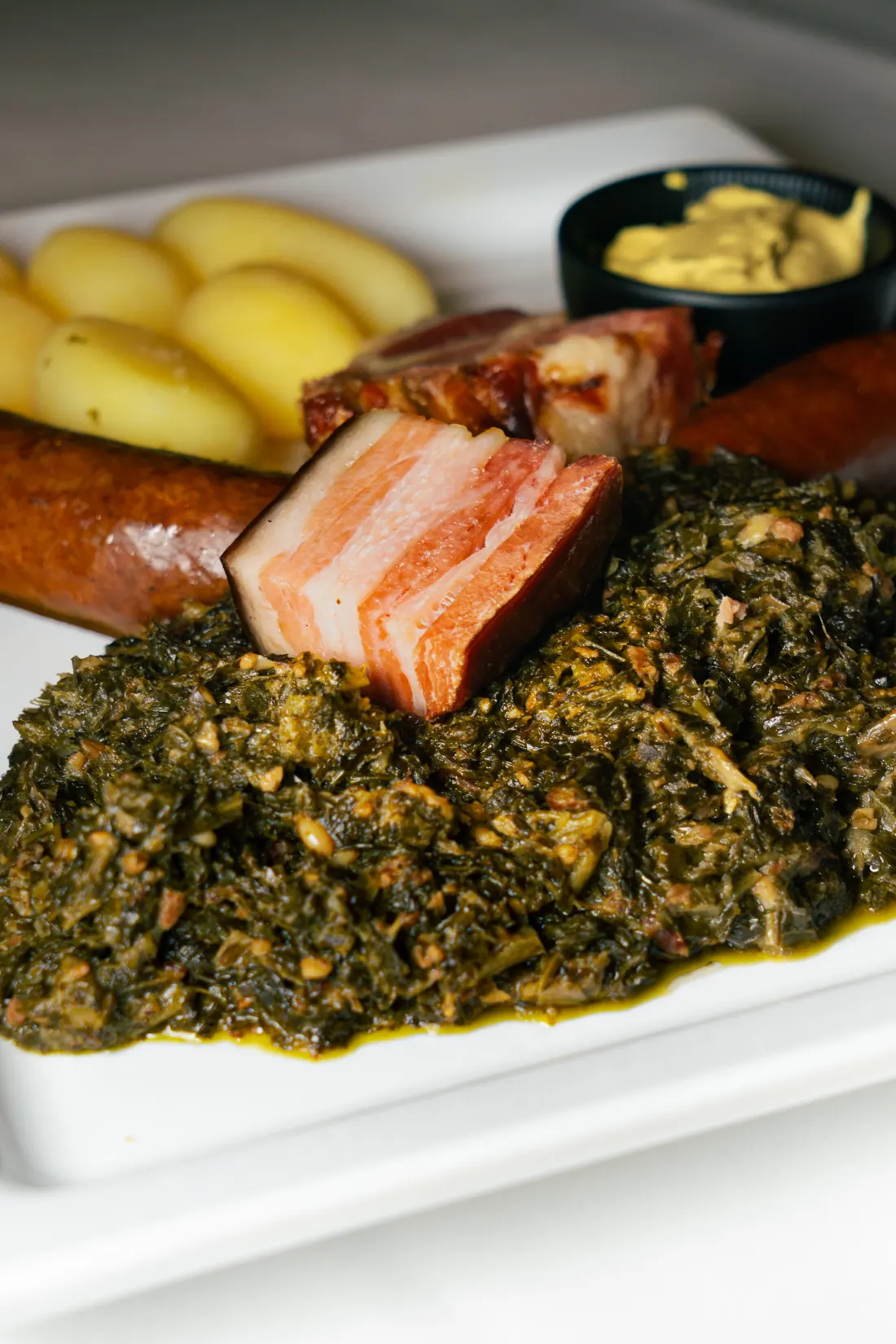 Grünkohlteller mit Pinkel, Kassler und Salzkartoffeln